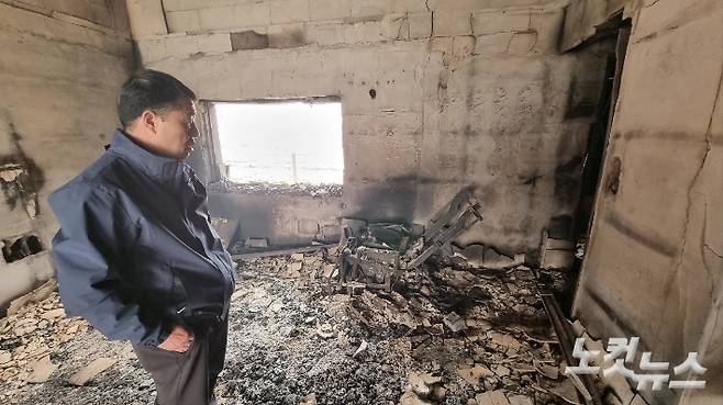 집에 탄 거실에 있던 안마의자를 보고 있는 이동진씨. 김대기 기자