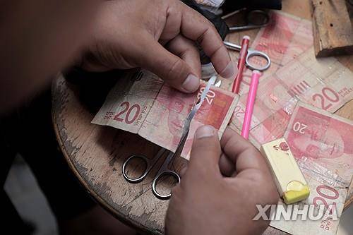 헌 지폐 '수선'하는 팔레스타인 남성 (가자지구 칸유니스 신화=연합뉴스) 2024년 9월 30일 가자지구 남부 칸유니스에서 한 팔레스타인 남성이 헌 지폐를 '수선'하고 있다.  (Photo by Rizek Abdeljawad/Xinhua) 2025.3.26.