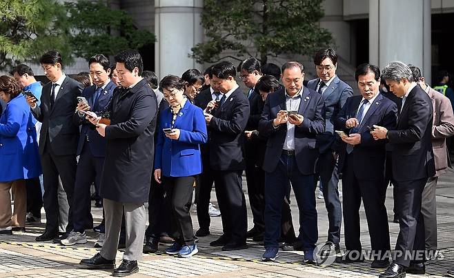 뉴스 속보 보는 의원들 (서울=연합뉴스) 더불어민주당 이재명 대표의 공직선거법 위반 사건 항소심이 열린 26일 서울 서초구 서울고등법원에서 동료 의원들이 휴대전화로 뉴스속보를 보고 있다. 2025.3.26 [사진공동취재단] photo@yna.co.kr