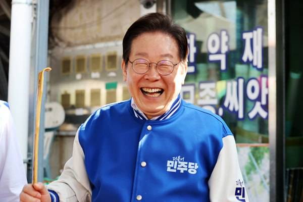 ▲더불어민주당 이재명 대표가 지난 22일 오전 전남 담양시장에서 이재종 후보 지원 유세를 하는 과정에서 상인이 건넨 효자손을 보며 웃고 있다. ⓒ연합뉴스