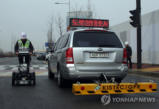 2015년 경기도 고양시 EBS 통합사옥 신축 공사장 인근 도로에서 한국시설안전공단 직원들이 지하 빈공간을 찾는 지표투과레이더(GPR) 장비를 시연해 보이고 있다. [사진 출처 = 연합뉴스]
