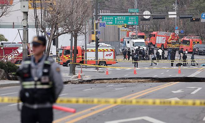 25일 서울 강동구 대명초등학교 인근 사거리에서 전날 발생한 싱크홀 사고 현장의 모습이 보이고 있다. 뉴스1