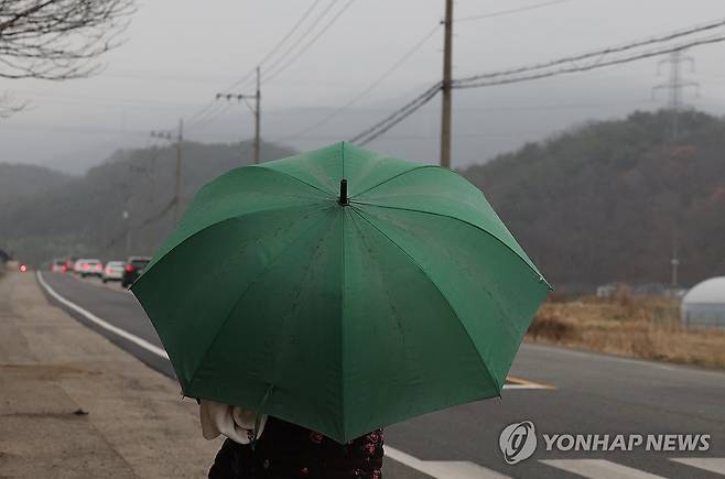울주 산불 지역에 내리는 단비 (울산=연합뉴스) 김용태 기자 = 27일 엿새째 산불이 이어지고 있는 울산시 울주군 온양읍에 비가 내려 외광리 한 마을 주민이 우산을 쓰고 걸어가고 있다. 2025.3.27 yongtae@yna.co.kr