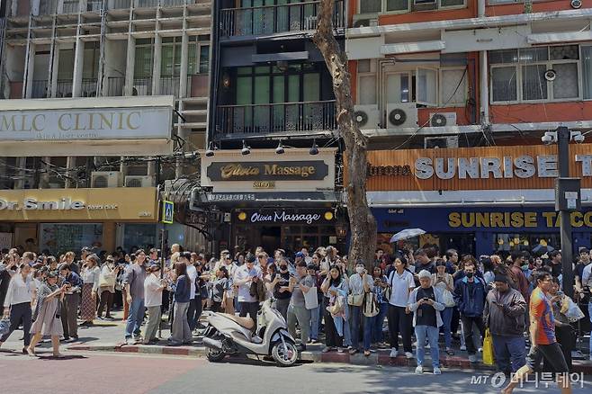 [방콕(태국)=AP/뉴시스]28일 이웃 미얀마에서 발생한 규모 7,7의 지진 영향으로 태국 방콕에서도 건물들이 크게 흔들리자 놀란 시민들이 건물 밖으로 대피해 있다. 태국 수도 방콕에서 이웃 미얀마에서 발생한 규모 7.7 지진의 영향으로 신축 중이던 고층 건물이 무너졌다고 태국 경찰이 28일 밝혔다. 이로 인해 인명 피해가 발생했는지는 아직 알려지지 않고 있다. 2025.03.28.