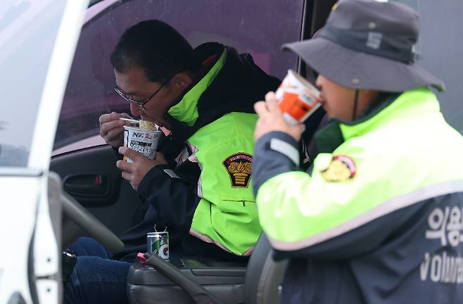 28일 오전 경북 안동시 낙동강변 둔치에 마련된 소방지휘본부에서 산불을 진압하던 의용소방대원들이 차 안에서 컵라면을 먹고 있다. 연합뉴스