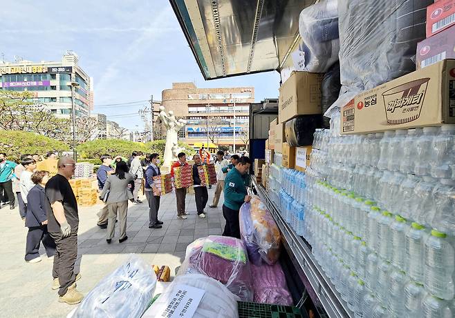 28일 광주 북구청 광장에서 구청 직원들과 후원단체가 산불 피해를 본 경남 산청과 하동 주민들을 돕기 위한 생수, 빵, 라면, 담요 등의 구호 물품을 차량에 싣고 있다. 연합뉴스