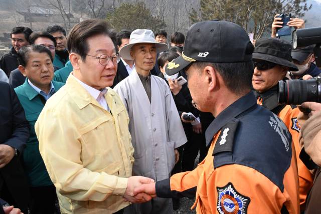 이재명 더불어민주당 대표가 27일 경북 의성군 단촌면 고운사를 찾아 산불 피해 상황을 살펴보던 중 소방대원들을 격려하고 있다. 조태형 기자