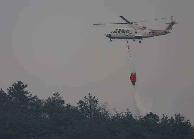 28일 경북 영양군 석보면 일대에서 산불진화 헬기가 방수 작업을 하고 있다. 연합뉴스