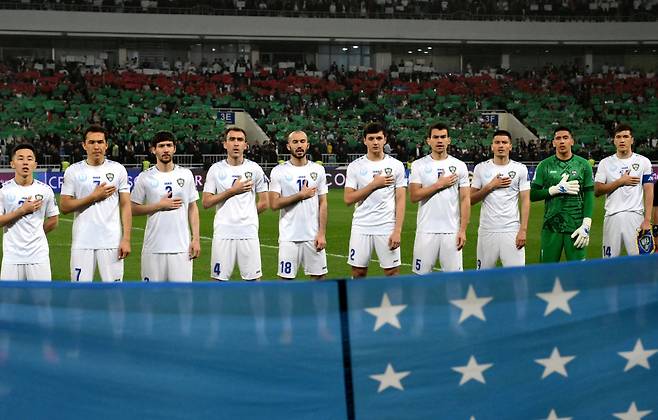 우즈베키스탄 축구대표팀 선수들이 지난 20일 북중미월드컵 아시아 3차예선 키르기스스탄전에 앞서 국기에 대한 경례를 하고 있다. Getty Images코리아