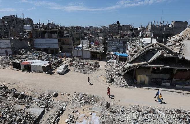 폐허 된 가자지구 (칸유니스 로이터=연합뉴스) 27일(현지시간) 가자지구의 폐허 속을 사람들이 걷고 있다. 2025.3.28 photo@yna.co.kr