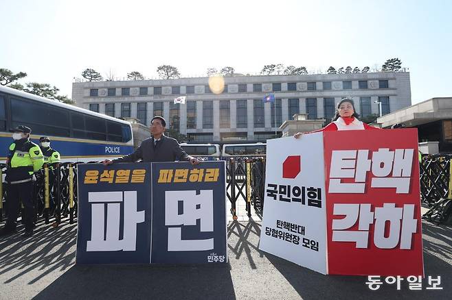 28일 서울 종로구 헌법재판소 앞에서 더불어민주당 김주영 의원(왼쪽)과 국민의힘 탄핵반대 당협위원장 모임 관계자가 나란히 서서 각각 윤석열 대통령 탄핵 인용과 각하를 주장하는 1인 시위를 하고 있다. 송은석 기자 silverstone@donga.com