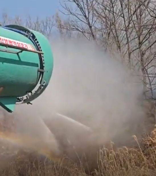 경북 구미 농부 이승민(47)씨가 4000ℓ 물을 100m까지 분사하는 대형 광역살포기로 경북 의성 안사면 민가로 번지는 산불을 끄고 있다. 사진 이승민씨 제공