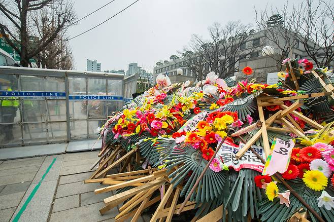 줄탄핵으로 정치권이 해결하지 못한 '갈등의 설거지'가 쌓여가는 헌재. 이런 '정치의 사법화'로 인해 입법부는 극단적 갈등으로 치닫고 사법부에 대한 불신이 쌓이면서 삼권분립과 법치주의라는 민주주의 근간이 흔들리고 있다. 지난 25일 윤 대통령 지지자들이 보낸 화환이 철거돼 헌재 앞 한 켠에 쌓인 모습. /김용재 영상미디어 기자