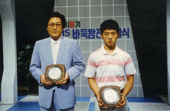 1989년 이창호가 제8회 바둑왕전에서 우승한 뒤. 왼쪽이 당시 결승전에서 패한 김수장 7단이다. 14세 나이로 바둑왕전에서 우승한 이창호는 세계 최연소 타이틀 획득 기록을 세운다. 사진 한국기원