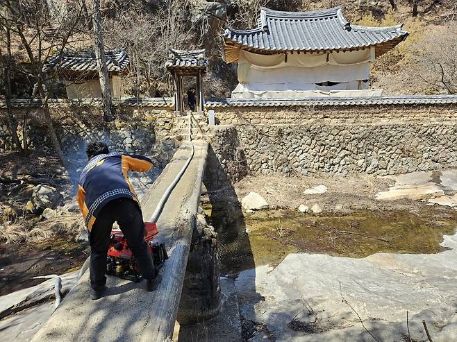 30일 정오쯤 경북 안동시 길안면 묵계리 만휴정에서 소방대원이 동력펌프로 물을 뿌릴 준비를 하고 있다.   김재산 기자