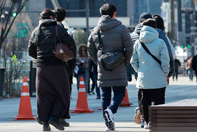 찬 바람이 불면서 꽃샘추위가 계속되는 30일 오전 서울 종로구 광화문광장에서 외국인들이 지나가고 있다. 뉴시스