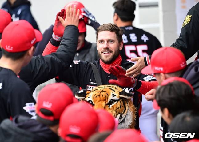 KIA 위즈덤(가운데)이 29일 대전 한화전 1회초 홈런을 때려내고 팀원들과 함께 미소짓고 있다.