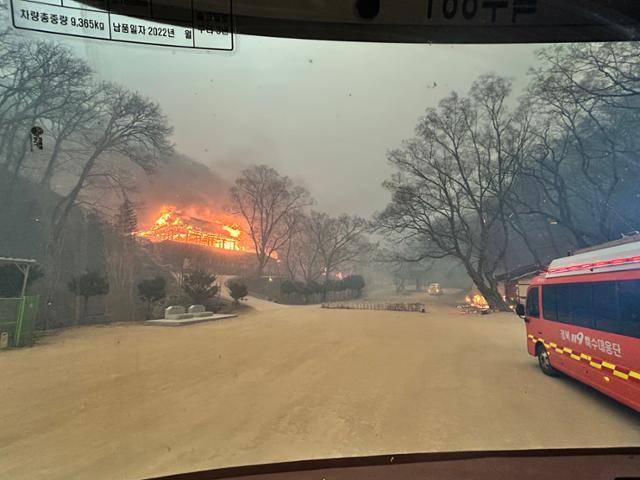 25일 경북119특수대응단 3팀 대원들이 경북 의성군 고운사 입구 주차장에 도착해 바라본 경내 전각이 전소되고 있다. 강대현 소방장 제공