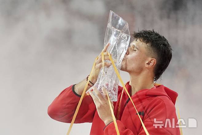 [마이애미=AP/뉴시스] 야쿱 멘식(54위·체코)이 30일(현지 시간) 미 플로리다주 마이애미가든에서 열린 남자프로테니스(ATP) 마이애미 오픈 단식 정상에 올라 트로피를 들고 입 맞추고 있다. 올해 19세인 멘식은 결승전에서 투어 레벨 통산 100승을 노리던 노바크 조코비치(5위·세르비아)를 2-0(7-6 7-6)으로 꺾고 정상에 올랐다. 2025.03.31.