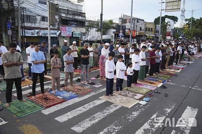 [자카르타=AP/뉴시스] 31일(현지 시간) 인도네시아 자카르타 거리에서 무슬림들이 라마단 성월의 끝을 알리는 이드 알피트르 기도를 올리고 있다. 2025.03.31.