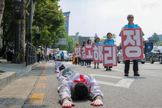 세종호텔 정리해고 노동자들이 2023년 9월 19일부터 2박 3일간 진행했던 오체투지 행진 모습. 이들은 부당해고 철회를 요구하며 서울행정법원에서 용산 대통령실을 거쳐 세종호텔까지 거리 위를 기어서 행진했다.&nbsp;