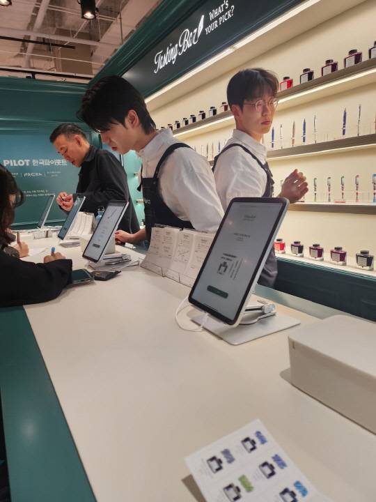 2일 서울 삼성동 코엑스에서 열린 '인벤타리오 : 2025 문구 페어' 내 '한국파이롯트' 부스에서 김진표(왼쪽 첫번째) 한국파이롯트 대표가 방문객의 시필을 돕고 있다. 사진= 김수연기자 newsnews@dt.co.kr