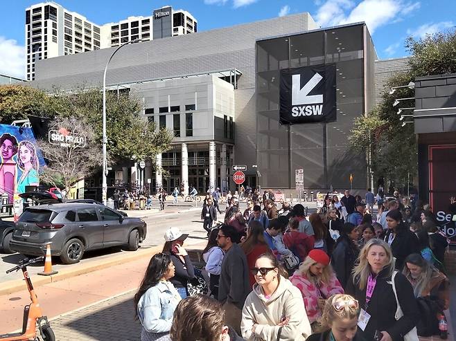 미국 텍사스주 오스틴시 오스틴컨벤션센터 근처 에이아이(AI)하우스에 들어가려는 관람객들이 기다리고 있다. 김광수 선임기자