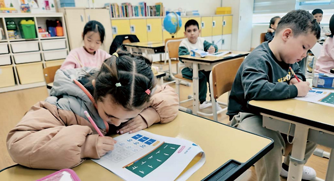 청주 봉명초 한국어학급 1반의 한국어 수업 시간에 러시아에서 온 1학년 사미라가 한글 모음을 쓰고 있다. [사진 = 지혜진 기자]