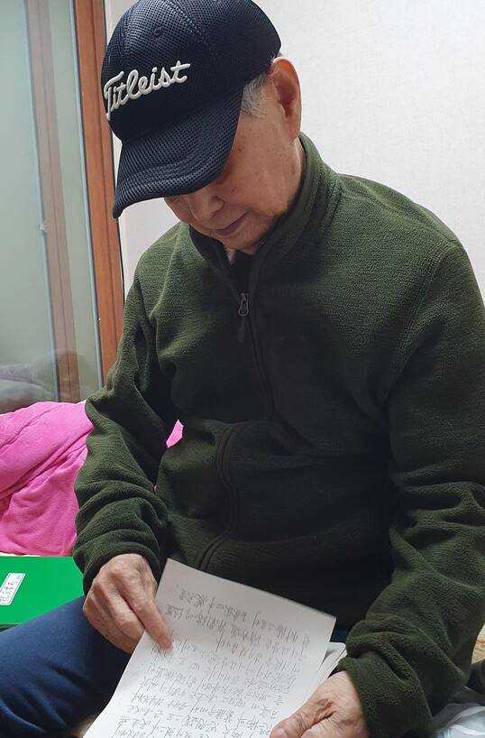 김양학씨가 자신이 쓴 ‘토산리 실상기’를 보고 있다. 허호준 기자