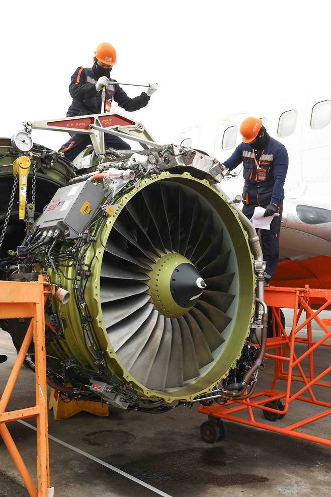제주항공 정비팀이 B737-800 기체의 엔진을 해체하고 있다. 수백 kg에 달하는 항공기 엔진을 정밀한 매뉴얼에 따라 하나하나 분리하고 있다. 바람막이조차 없는 활주로 한복판, 이들의 손끝은 조용하지만 단단하다. (제주항공 제공)