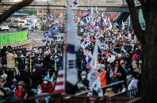 윤석열 대통령 탄핵심판을 앞둔 4일 서울 용산구 한남동 대통령 관저 앞에서 윤석열 대통령 탄핵 반대 집회 참가자들이 태극기와 성조기를 흔들고 있다./뉴시스