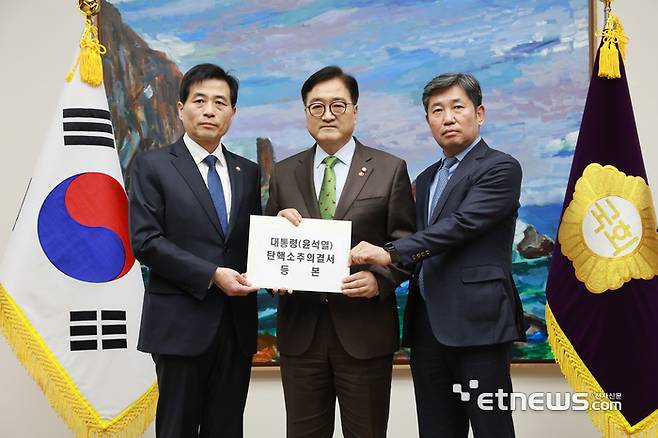 우원식 국회의장(가운데)이 14일 오후 서울 여의도 국회 국회의장 접견실에서 김민기 국회사무총장(왼쪽)에게 윤석열 대통령 탄핵 소추의결서를 전달하고 있다. 이동근기자 foto@etnews.com