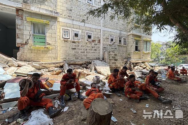 [네피도=AP/뉴시스] 3일(현지 시간) 미얀마 네피도에서 구조대원들이 지진 피해 건물 근처 그늘에 모여 휴식을 취하고 있다. 2025.04.03.