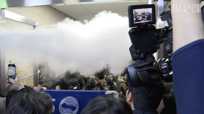 지난해 12월 3일 밤, 국회 보좌진들이 본청에 진입한 계엄군을 막아서고 있다