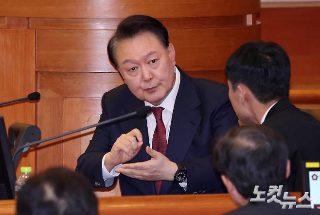 윤석열 대통령이 탄핵심판 4차 변론에 출석해 변호인단과 대화를 나누고 있다. 사진공동취재단