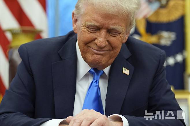 [워싱턴=AP/뉴시스] 도널드 트럼프 미국 대통령이 지난 2월 11일(현지 시간) 워싱턴DC 백악관 집무실에서 일론 머스크가 발언하는 걸 들으며 미소 짓고 있다. 2025.04.05.