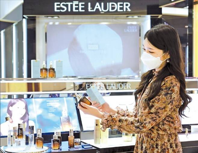 한 소비자가 에스티로더의 대표 제품 '갈색 병(어드밴스드 나이트 리페어 세럼)'을 살펴보고 있다. 롯데백화점 제공