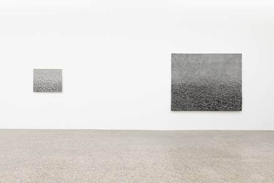 대구 리안갤러리 전시장. 이진우 작가의 숯과 한지 작품의 표면은 메말라 보이지만 그 아래 '물이 흐른다'는 작가의 상상을 깔고 있다. 생명을 품은 거친 대지의 형태를 닮았다. [사진 리안갤러리]