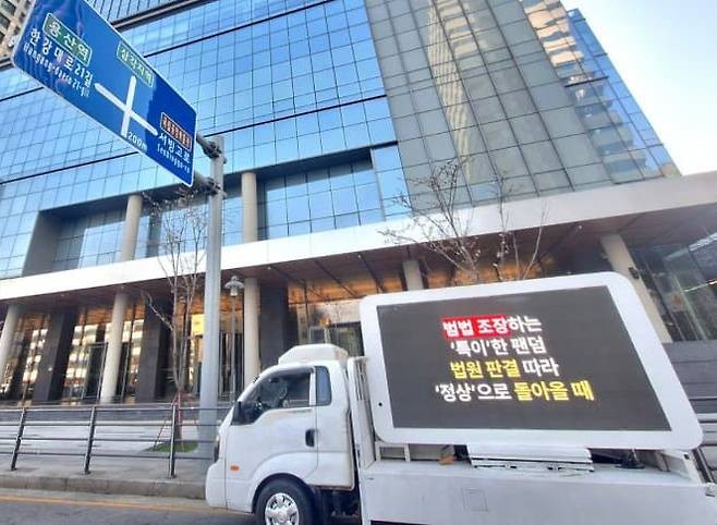 뉴진스 팬덤인 버니즈가 서울 용산에 있는 하이브 사옥 앞에서 소속사 복귀를 바라는 내용을 담아 트럭 시위를 벌이고 있다. /사진=온라인 커뮤니티 갈무리