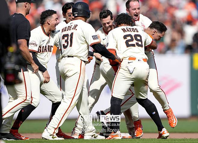 ▲ 끝내기 안타를 터뜨리고 동료들로부터 축하를 받고 있는 윌머 플로레스.