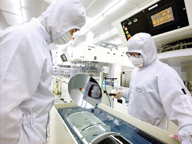 SK실트론 직원들이 웨이퍼 제품을 살피고 있다.  /한경DB