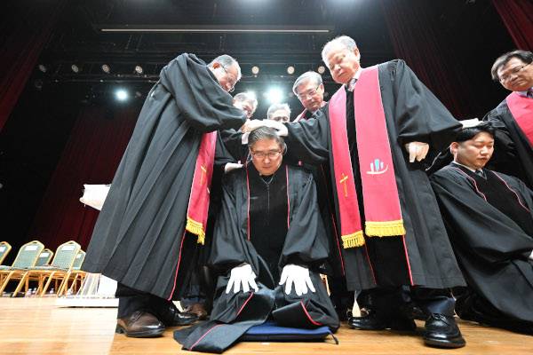 탈북민 출신 노희창(가운데) 목사가 7일 서울 동작구 CTS기독교TV 아트홀에서 열린 국제독립교회연합회 목사안수식에서 안수기도를 받고 있다. 신석현 포토그래퍼