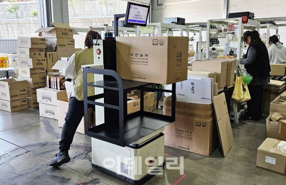 8일 경기 파주시 참물류 풀필먼트센터에서 트위니 자율주행 물류이송 로봇 ‘나르고 오더피킹’이 주문 제품 피킹을 마치고 포장 및 배송을 위한 패킹장으로 이동하고 있다.(사진=김범준 기자)