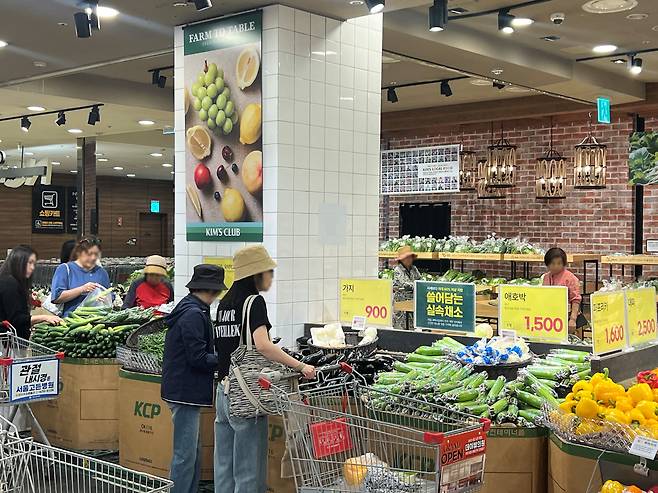 소비자가 이랜드리테일의 식품 전문 할인 매장 킴스클럽 '쓸어담는 실속채소' 코너에서 채소를 고르고 있다. 킴스편의점은 킴스클럽과 유사한 형태로 신선식품 관련 코너를 운영해 왔다. /이랜드 제공