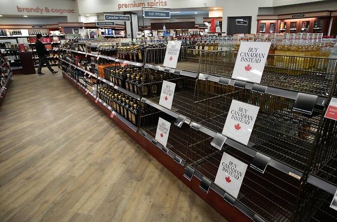 미국산 위스키가 치워진 마트 선반에 ‘캐나다산을 대신 사라’는 문구가 놓여 있다. AP 뉴시스