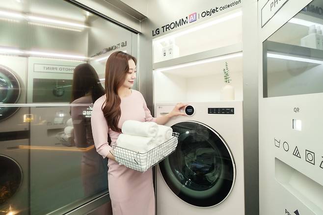 LG전자가 서울 동대문구 경동시장 '금성전파사 새로고침센터'에 마련한 AI 세탁·건조 체험존 '트롬하우스'에서 일체형 세탁건조기 LG 트롬 오브제컬렉션 워시콤보를 체험하는 모습