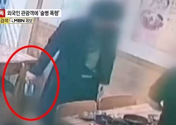 경찰이 서울 한복판에서 모르는 타이완 관광객을 술병으로 폭행한 남성을 쫓고 있다. 사진은 가해 남성이 식탁 위에 있던 술병을 들고 나가는 모습. /사진=MBN 캡처