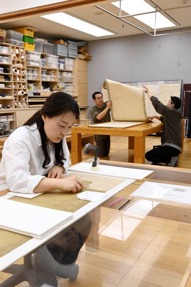 ‘묘향산도’ 병풍 복원 작업 중인 리움미술관 보존연구실 한국화보존팀.  문호남 기자
