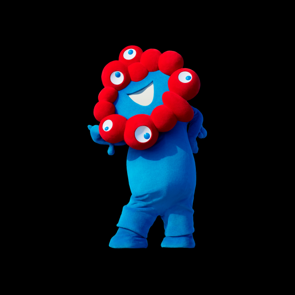 오사카 엑스포의 마스코트인 ‘먀쿠먀쿠’. 물의 도시 오사카를 연상시키는 파란색 캐릭터와 세포를 상징하는 붉은 동그라미가 합쳐진 모습을 하고 있다.