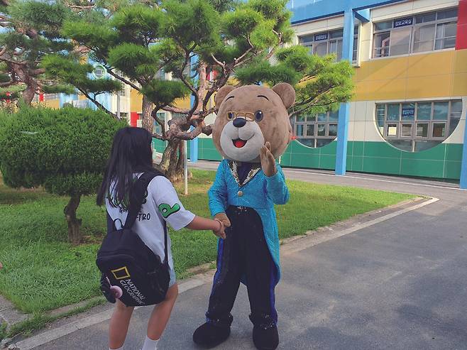 김주현 충남 광석초 교장이 2023년 9월 취임식 날 곰돌이 탈을 쓰고 학생들과 친근하게 인사를 나누는 모습. 
교육부 제공